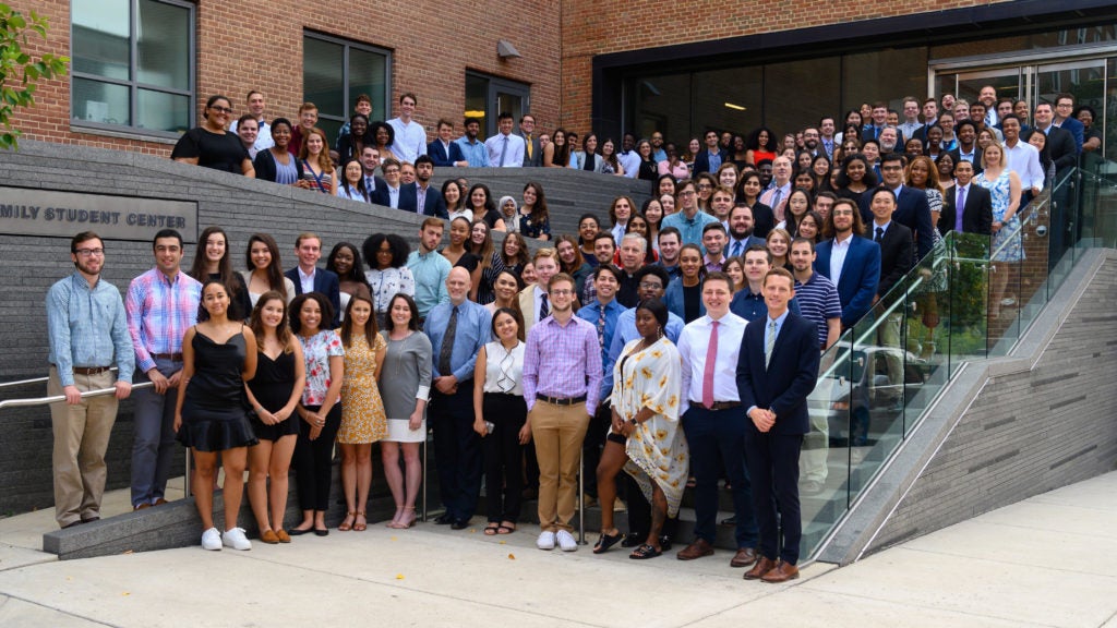 office of residential living professional and student staff in front of healy family student center