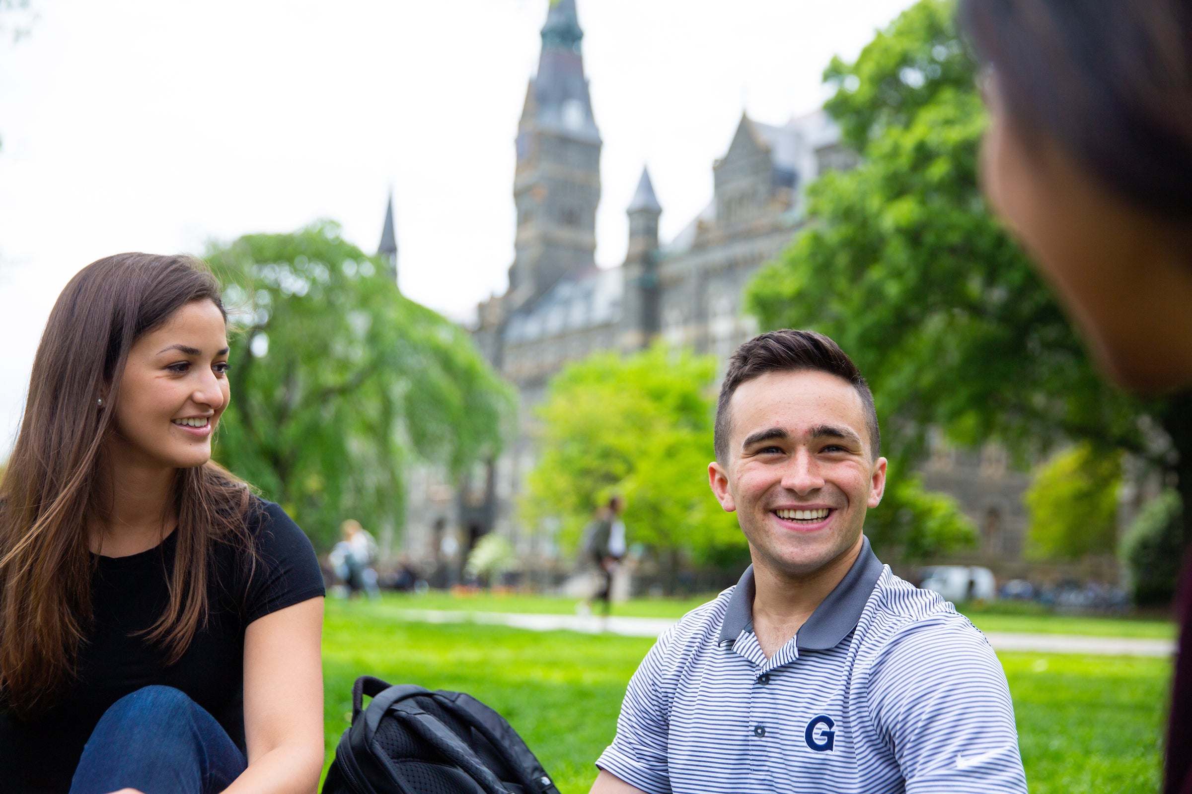 two students smiling on the lawn outside of Copley Hall.
