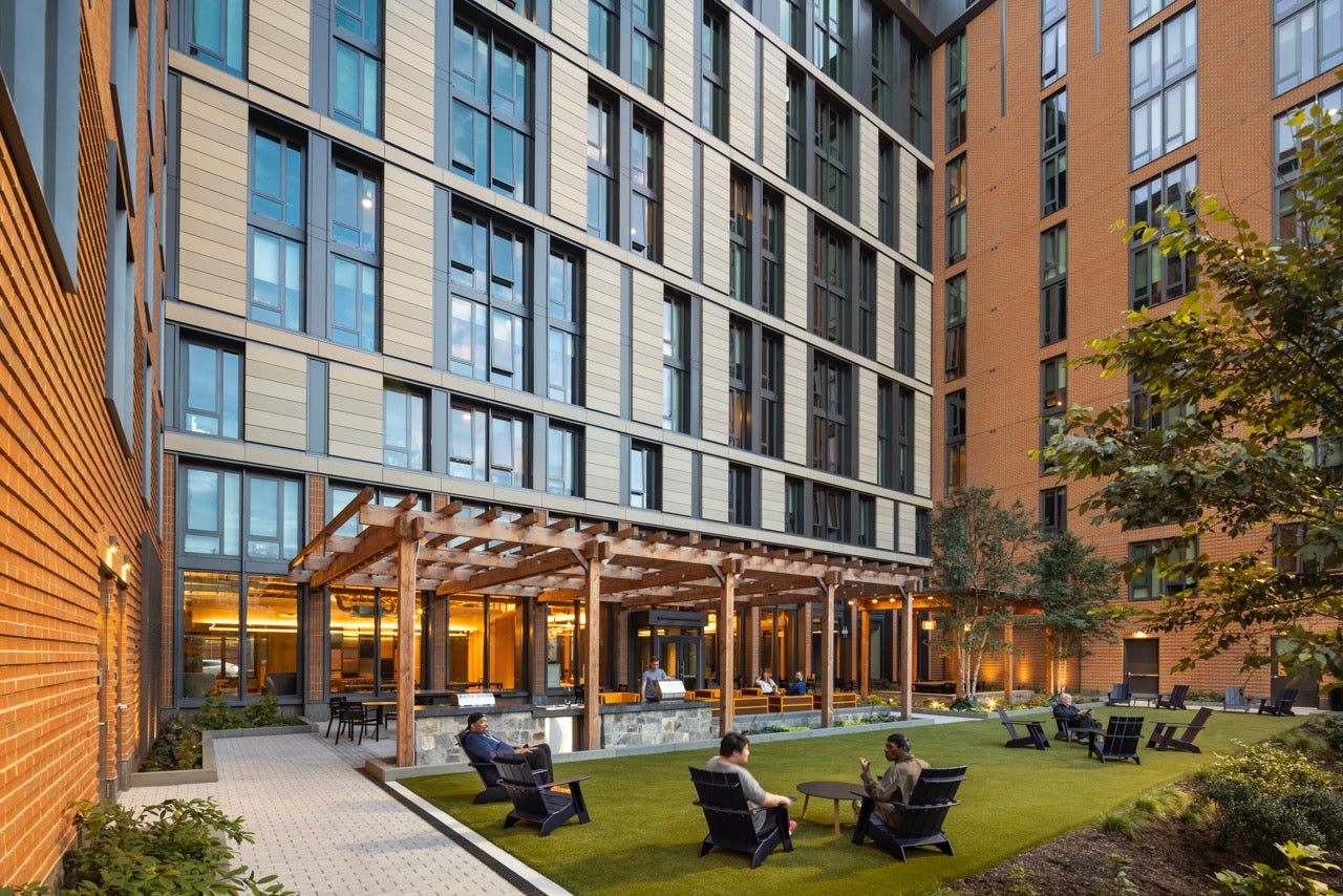 apartment building inner quad with Adirondack chairs, grills, and ping pong table