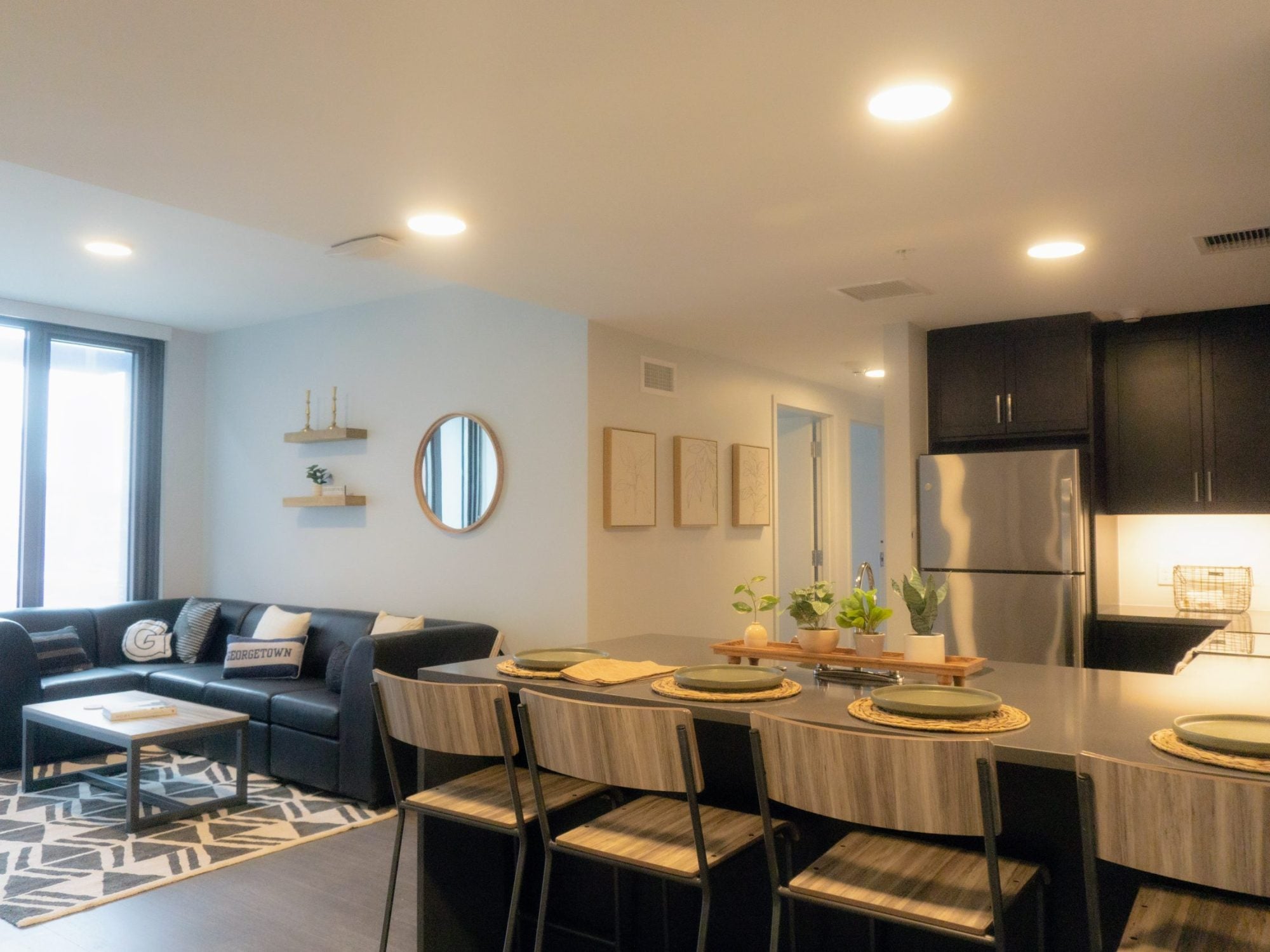 apartment interior common area with kitchen bar seating and leather couch