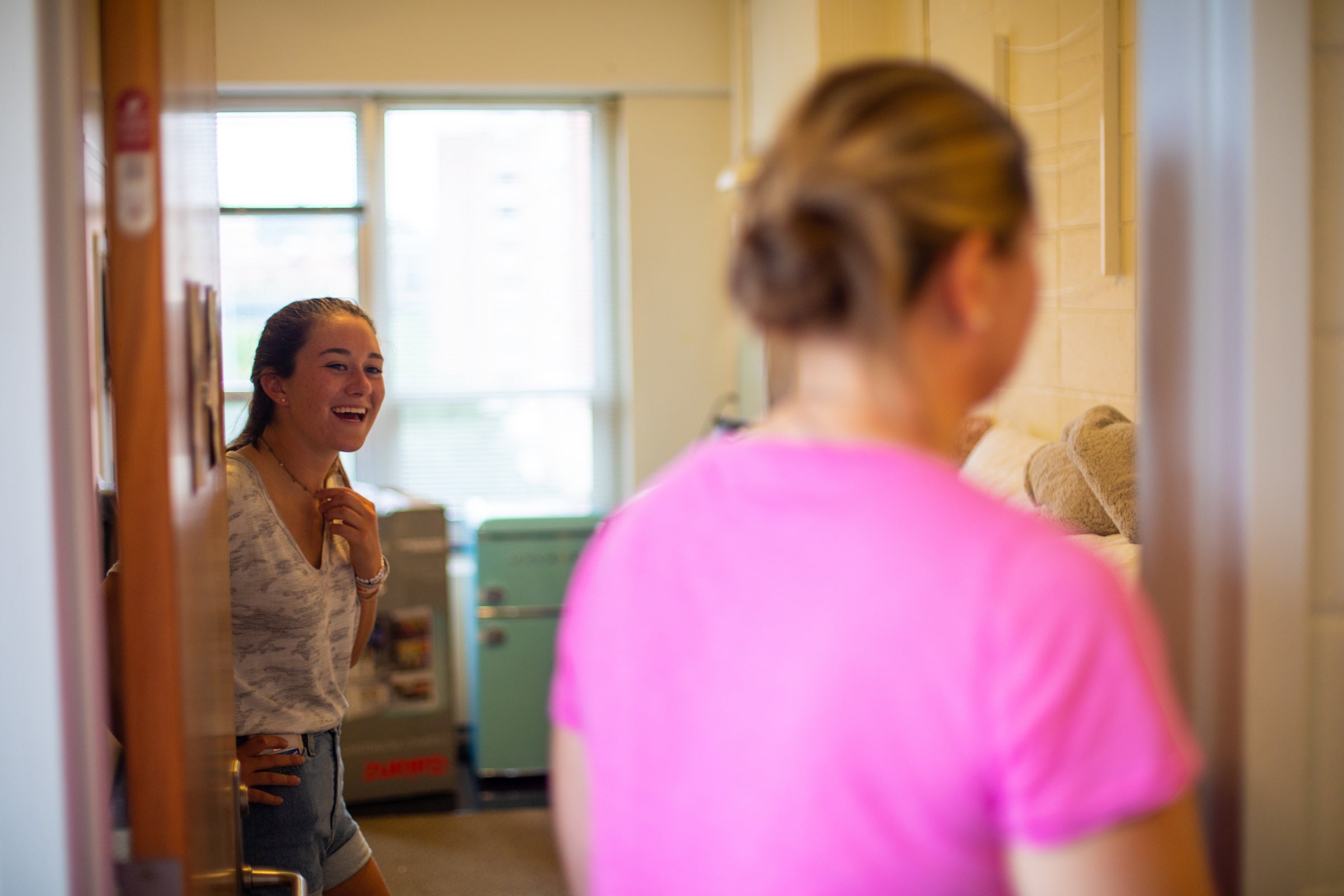 two female roommates, one smiling and one turned around, moving in