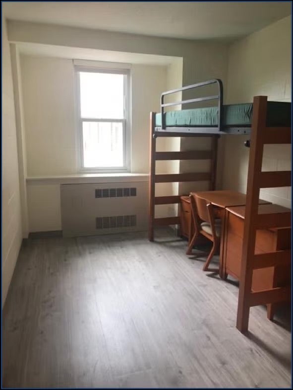 dorm with a raised bed and desk under the bed