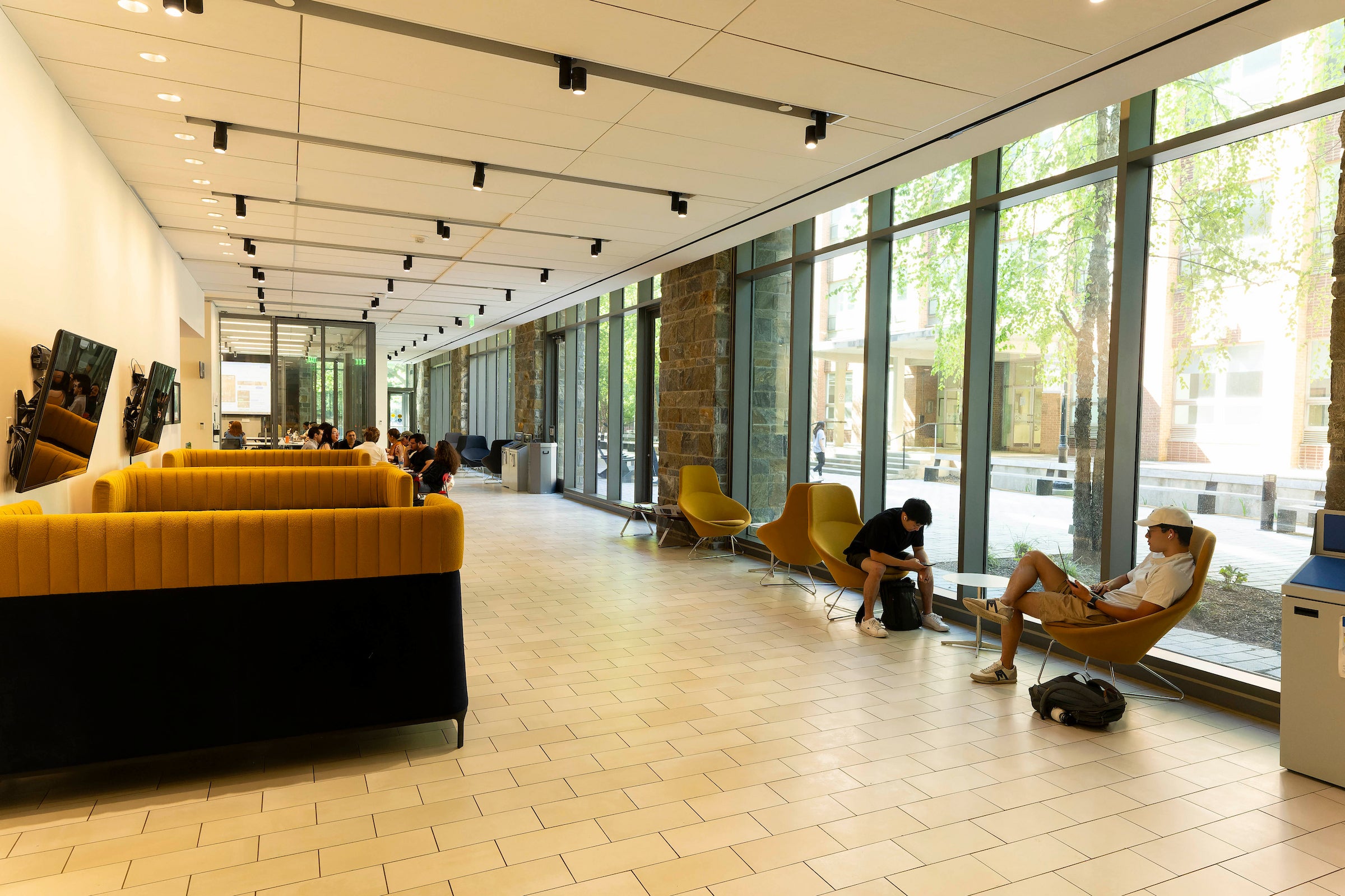 nice, new lobby corridor with lots of seating and glass windows looking out onto trees