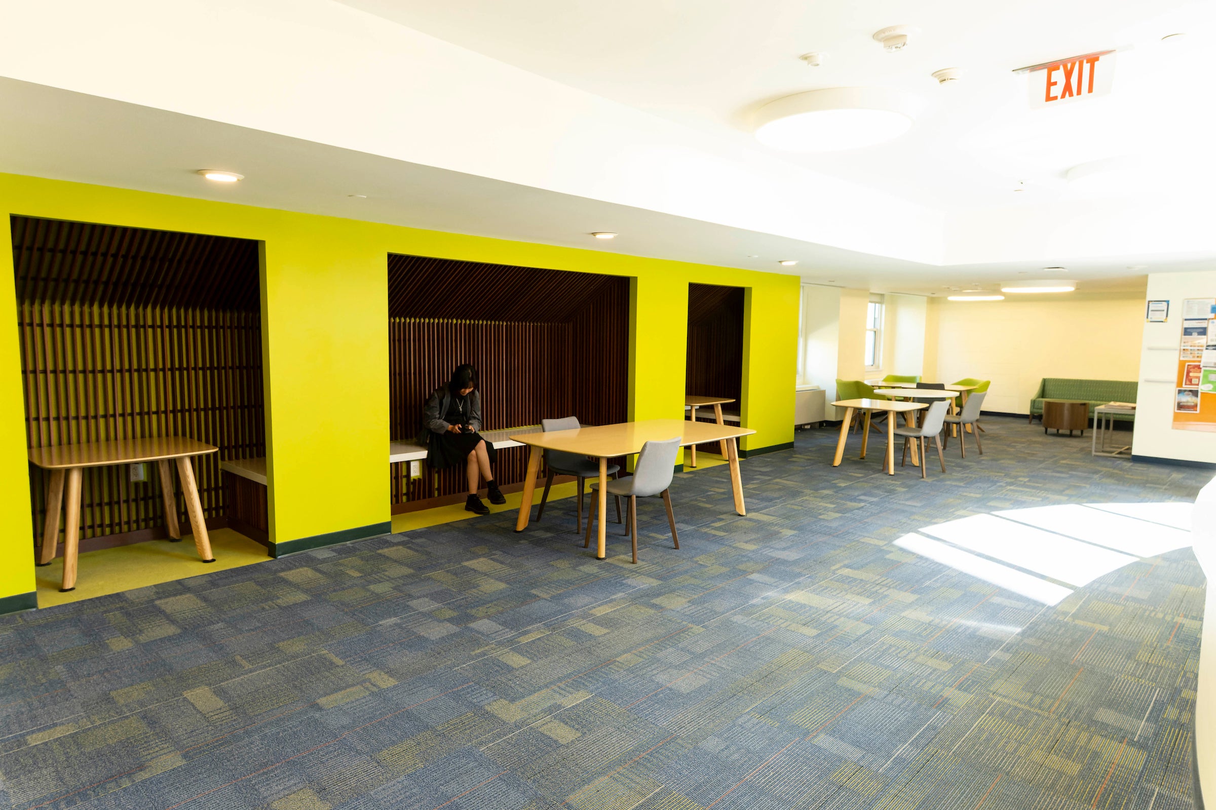 common area with carpet, furniture, and bright yellow walls. 