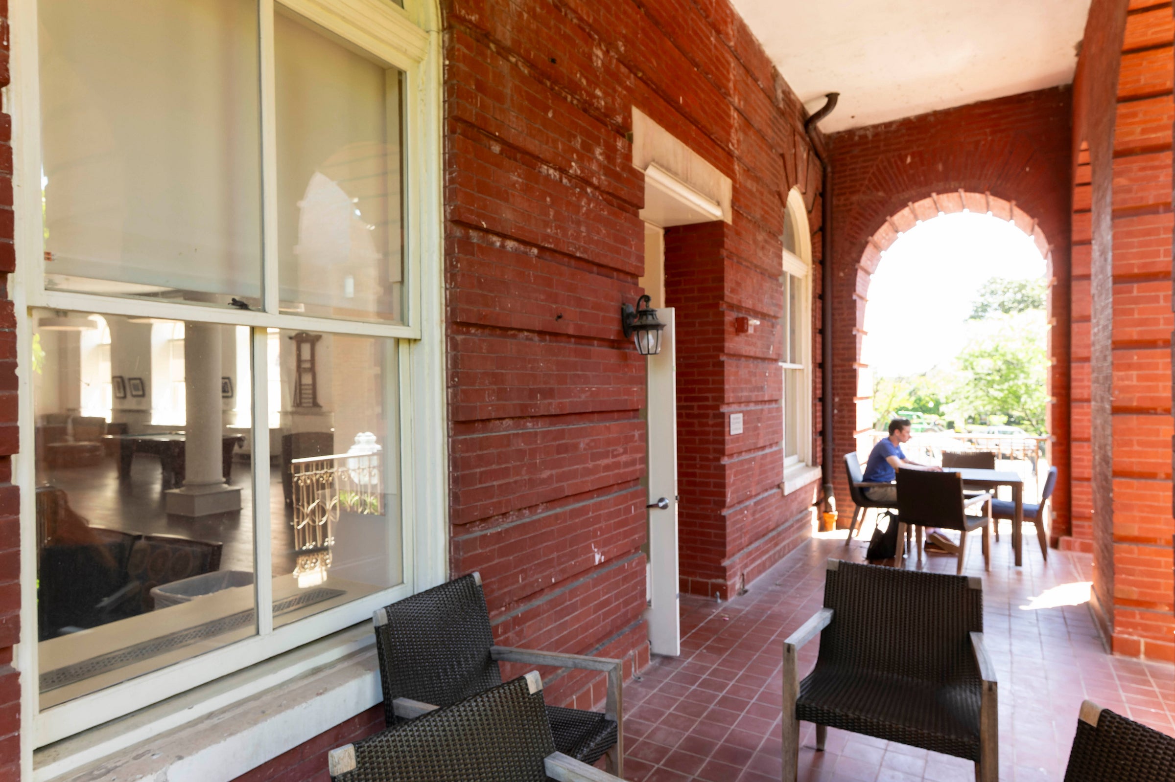 red brick building covered balcony with seating