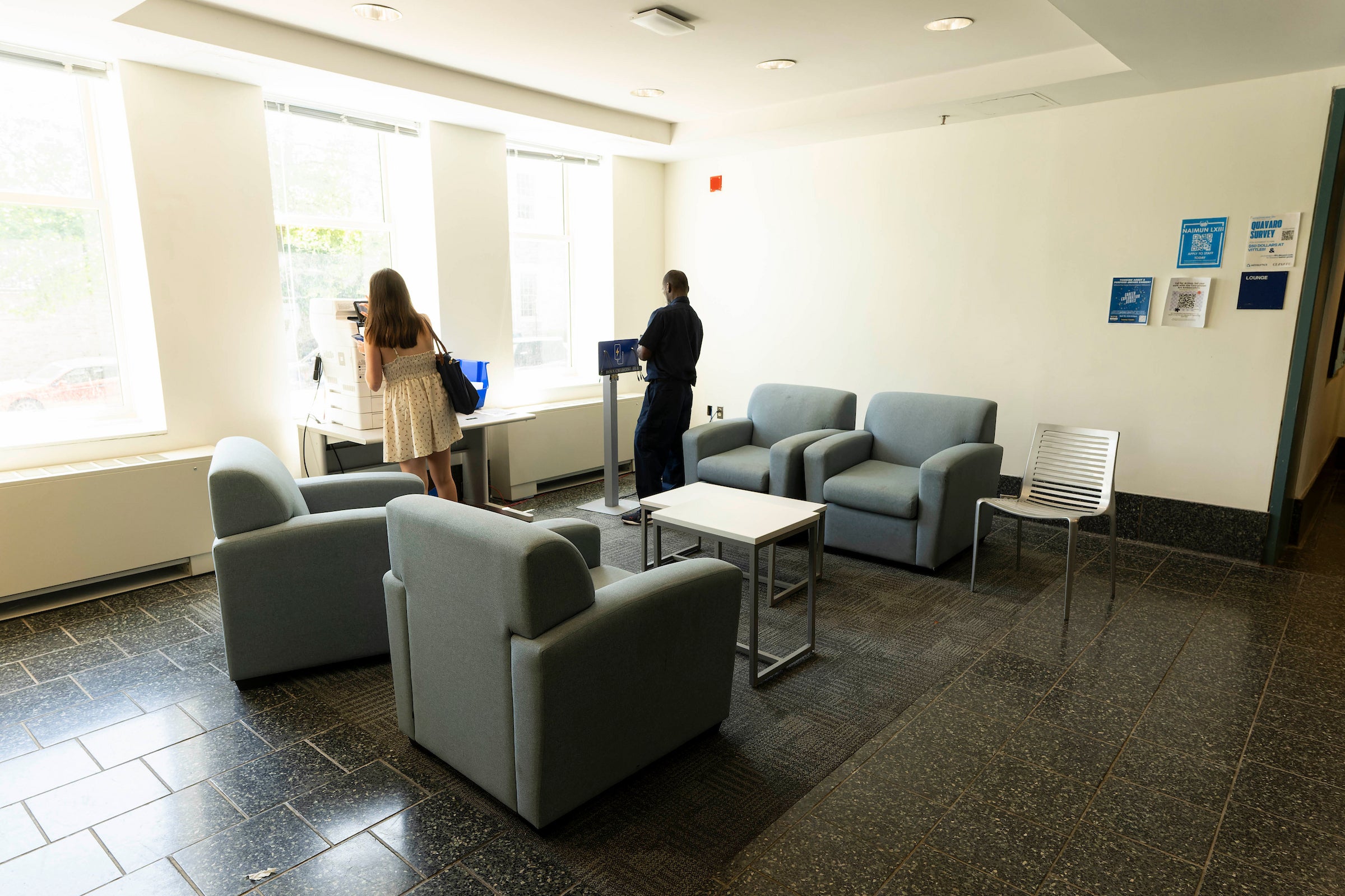building lounge with chairs and tables and a few people looking around
