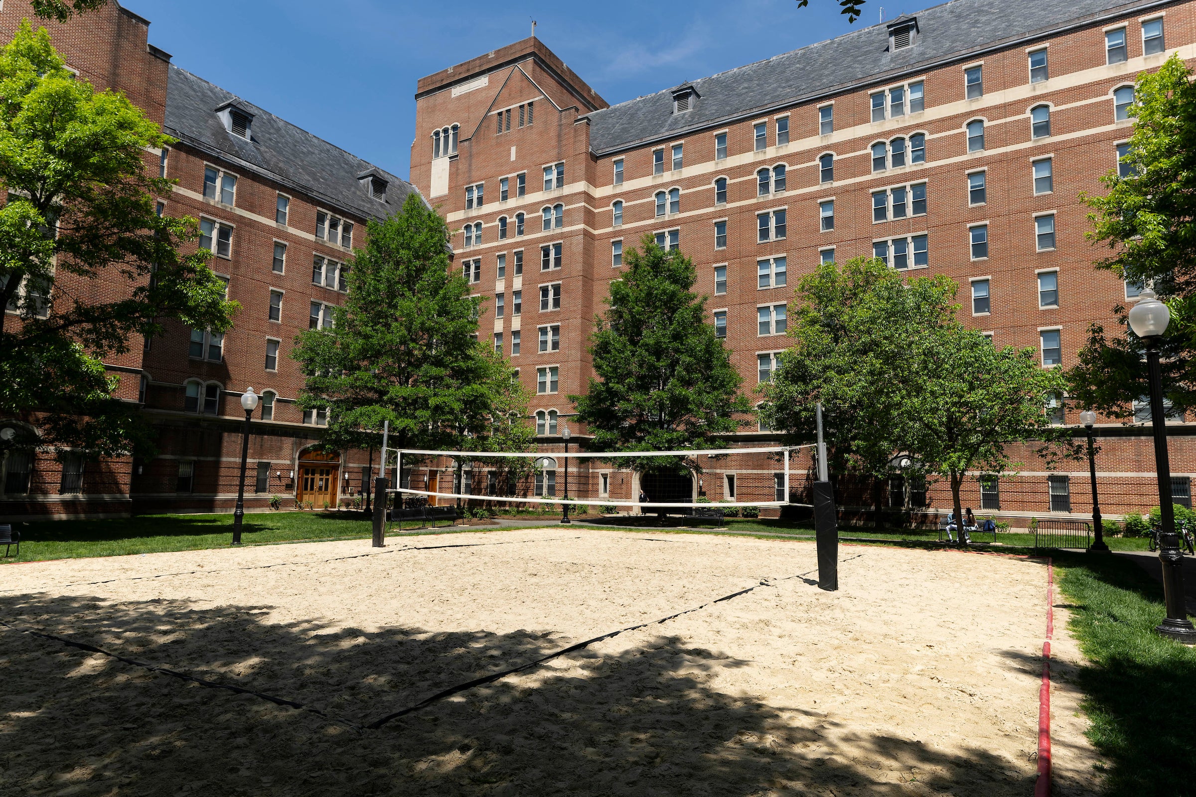 quad surrounded with brick buildings with an open and volleyball court in the center