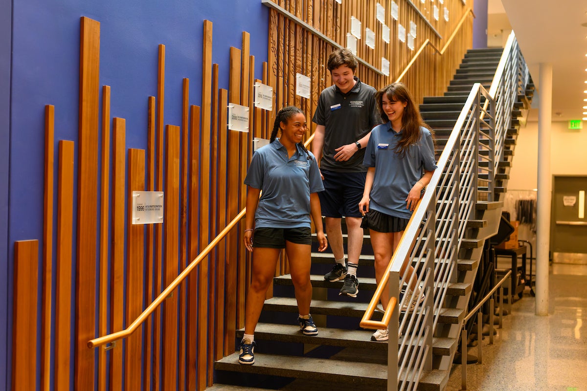 students in polos walking down steps