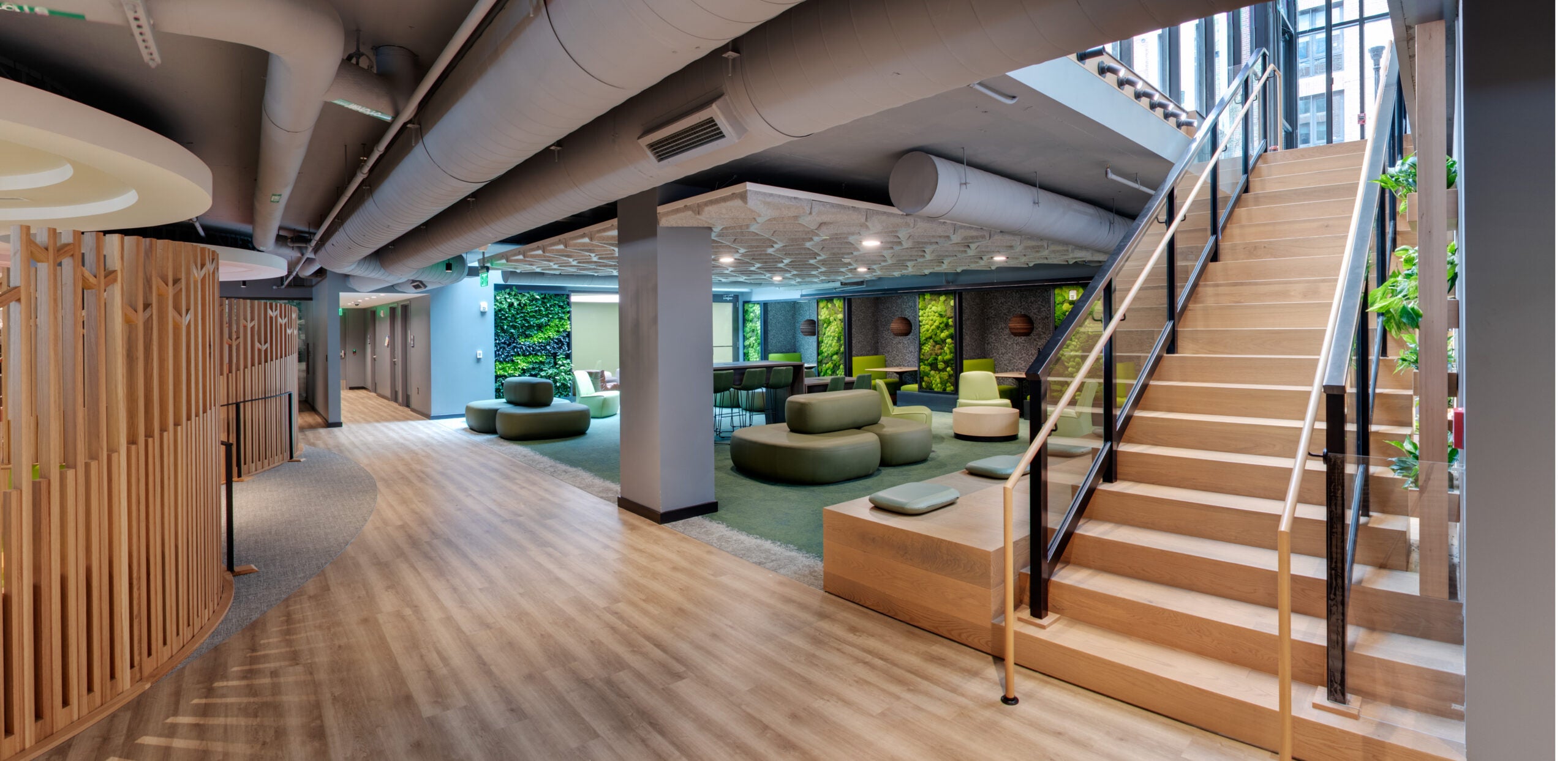 lounge with green furniture, plants on walls, and hardwood floors