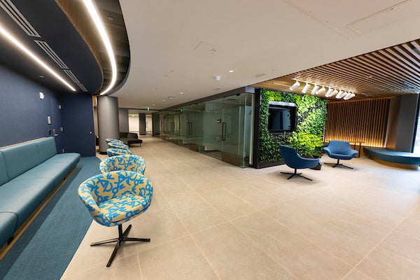 The lobby of Byrnes & Hayden featuring modern accent chairs and a plant wall.